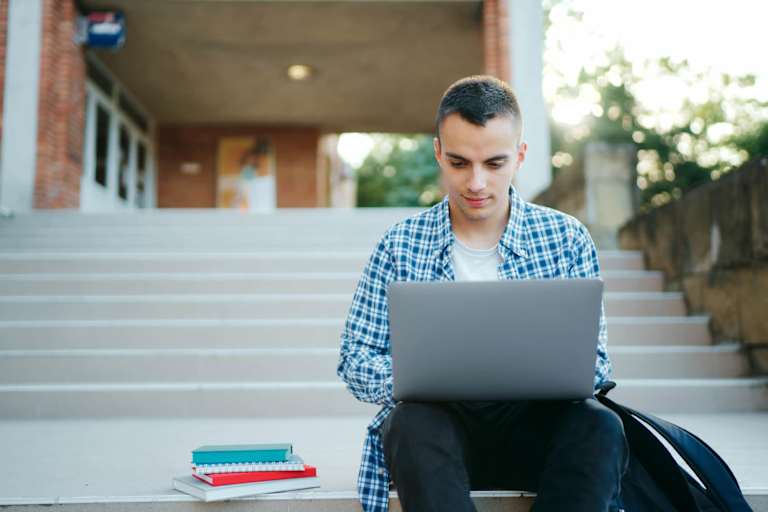 College student studying outside on laptop