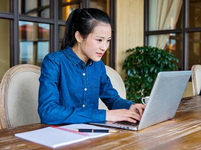 Woman typing on laptop at home